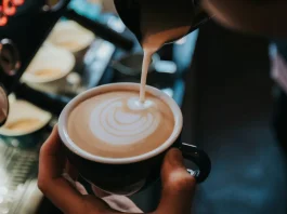 kávéra tejhabot önt a barista