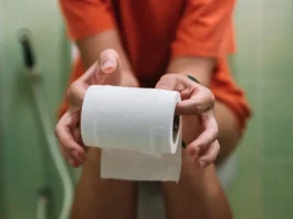 wc-n ül egy nő wc-papírt tart a kezében