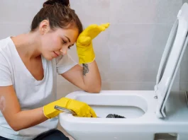 sárga gumikesztyűben wc-t takarít egy fiatal lány
