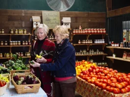 két idős hölgy zöldséget válogat a szupermarketben