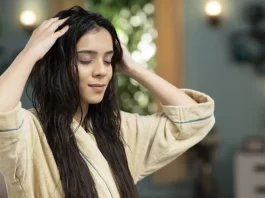 meleg olajos hajpakolást ken a hajára egy szép fiatal nő