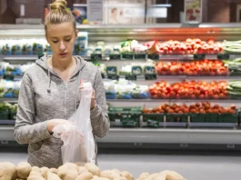 szép szőke nő krumplit válogat a boltban