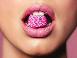 nő rúzsozott szájában cukor