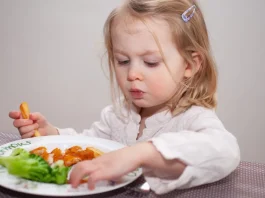 halrudacskát és sült krumplit eszik egy cuki kislány